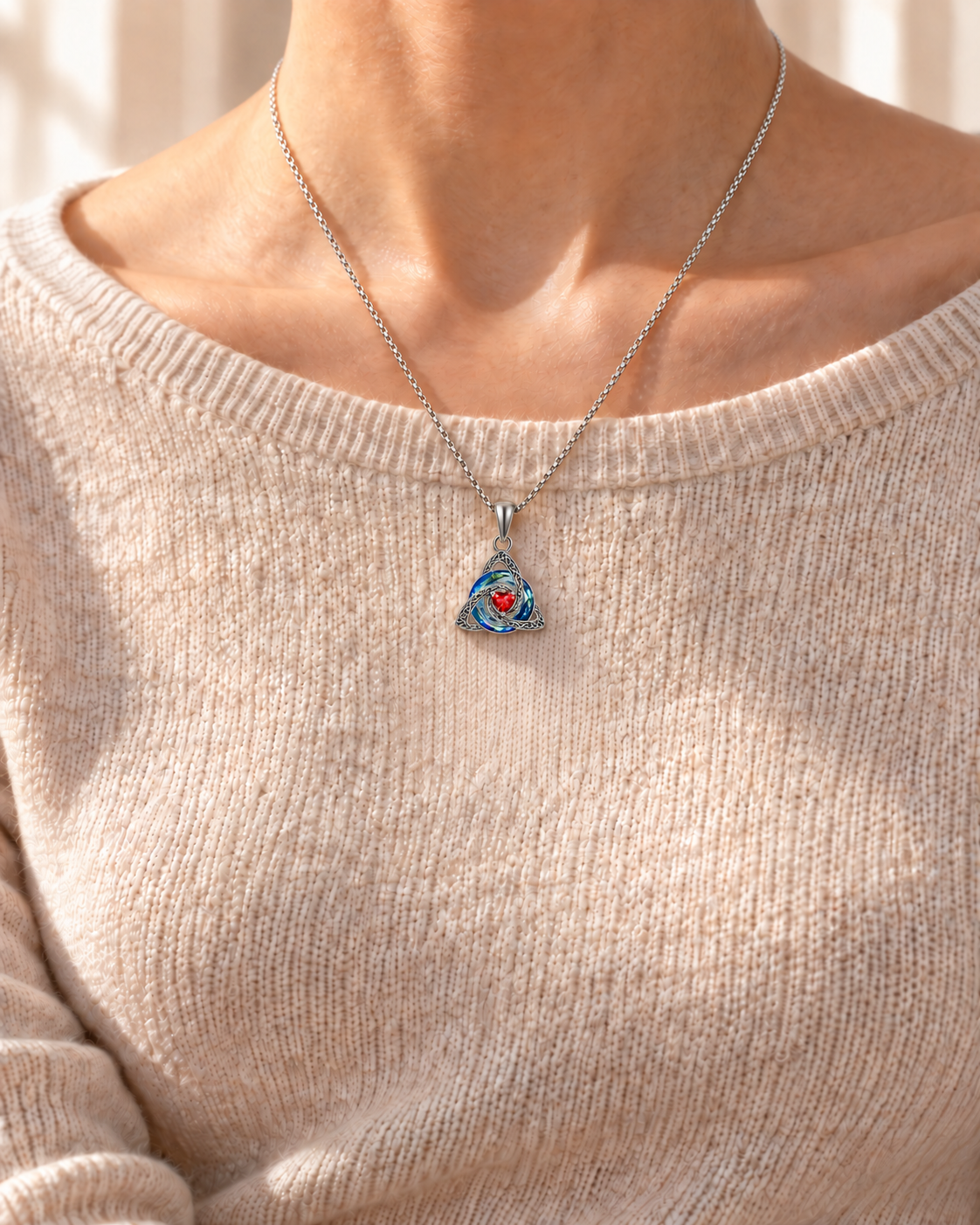 Mellowby editorial — January red Witch Knot necklace worn over an oatmeal knit top